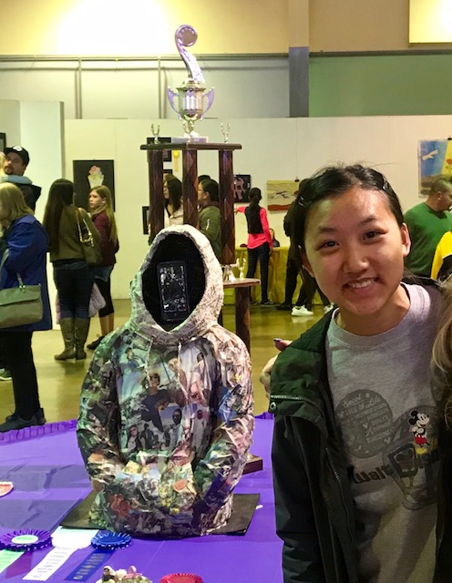 Liana shows off one of her accomplishments, Shrouded, at an art show in 2019.