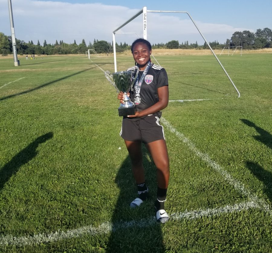 Nimi-Ngo shows off her trophy from soccer.