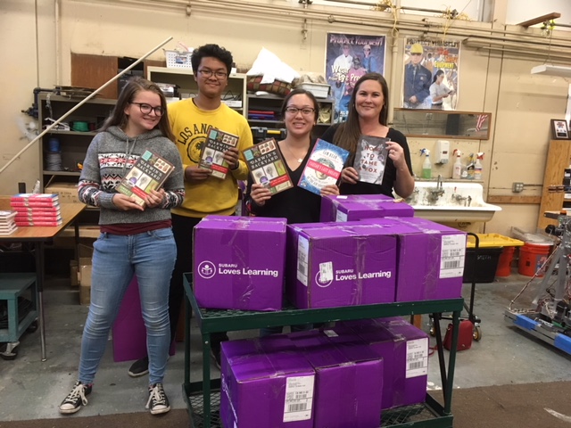 Robotics Club members Nicole Herston and Philip Jereza join two employees from Fairfield Subaru to promote the donation opportunity.