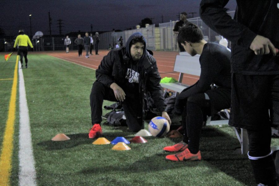 Coach Diaz explains strategy to one of his players.