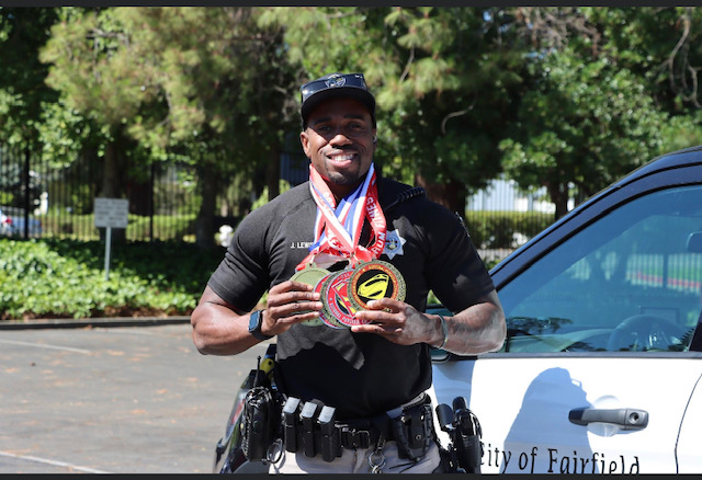 After competing in a men's physique competition, Officer James Lewis shows off his winnings.