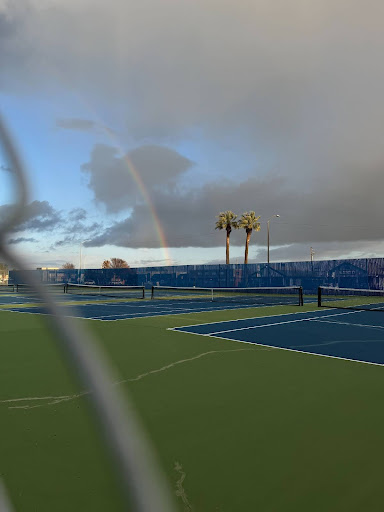 Springtime on the Tennis Court. A vibrant tennis court comes alive in the spring, with a rainbow arching across the sky, signaling the season of renewal & energy.